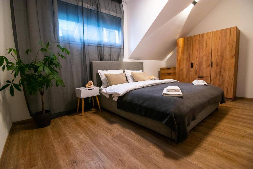 The attic bedroom of the Two-Bedroom Apartment — king bed under a sloped ceiling, oak wardrobe