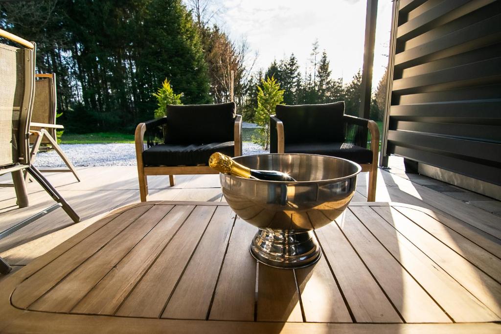 Golden-hour light across the terrace: lounge chairs and a champagne bucket on the wooden table